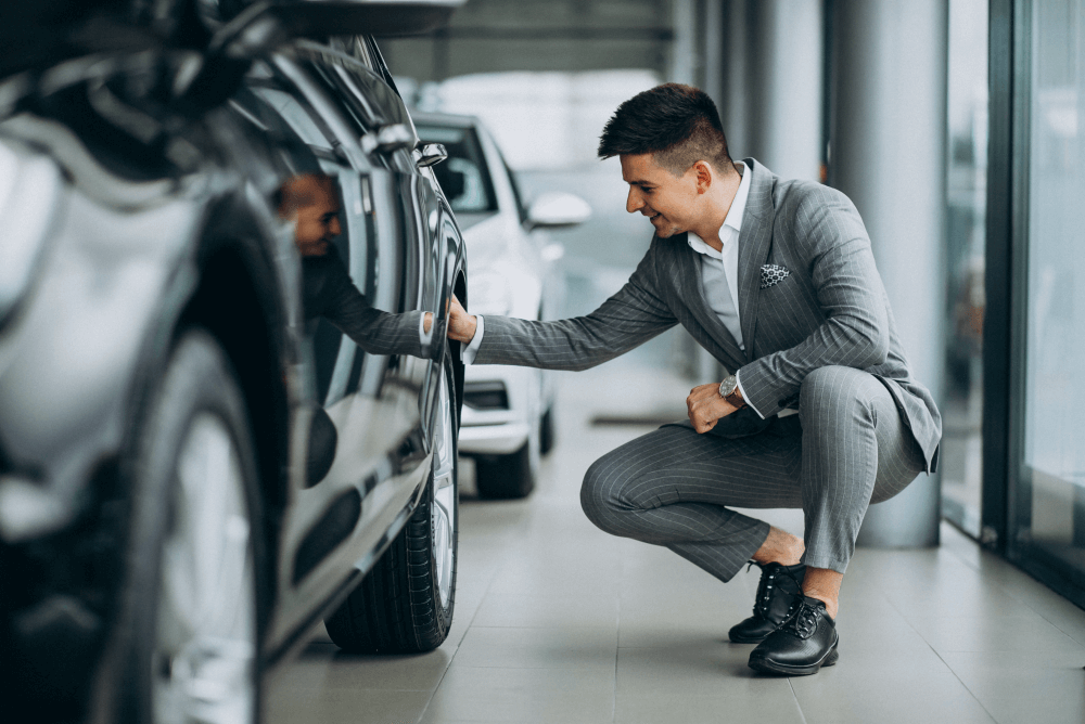 comprar um carro homem olhando pneu