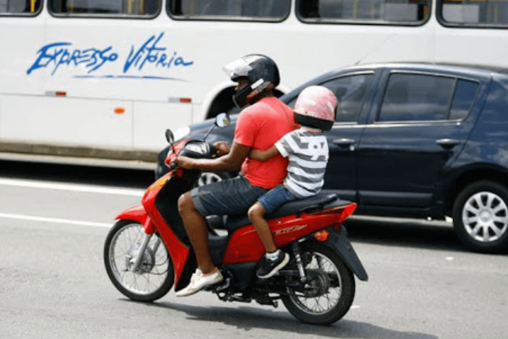 Imagem criança na moto abraçando o motociclista (Reprodução: Autocar Proteção Veicular) | DOK Despachante 