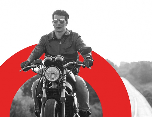 Capa de artigo seguro de moto - DOK Despachante; Descrição: jovem homem branco de óculos de sol e sem capacete pilotando motocicleta. Imagem em preto e branco.